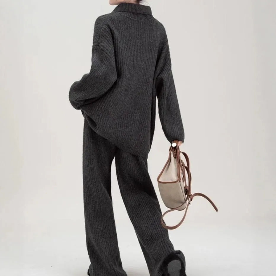 Dark grey sweater suit two-piece set with knit top and trousers showing collage stitching detail