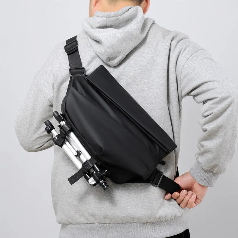 Men's grey crossbody bag with motorcycle sling strap, horizontal square shape, and zipper opening