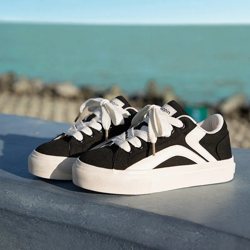Women's low-top lace-up board shoes in synthetic leather with a vulcanised rubber sole.
