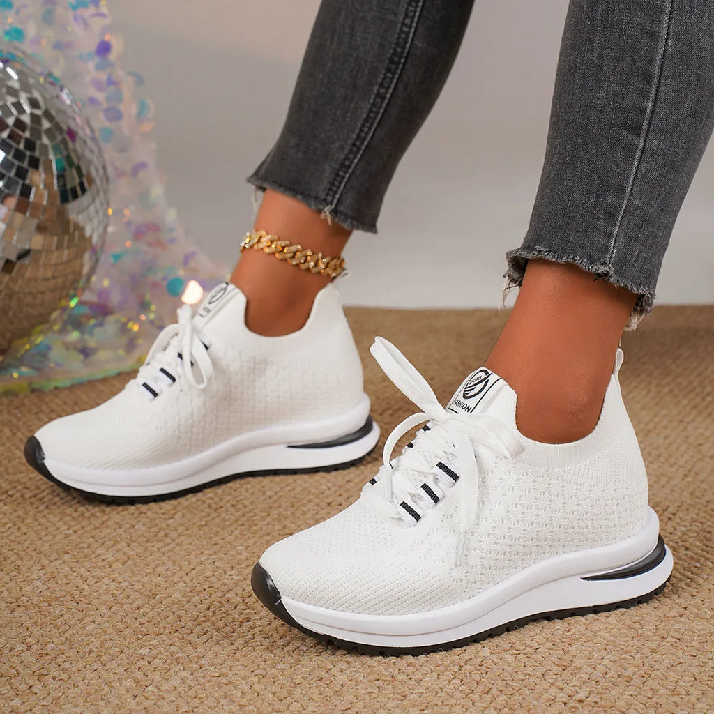 Women's black and white flat lace-up mesh sneakers on a white background