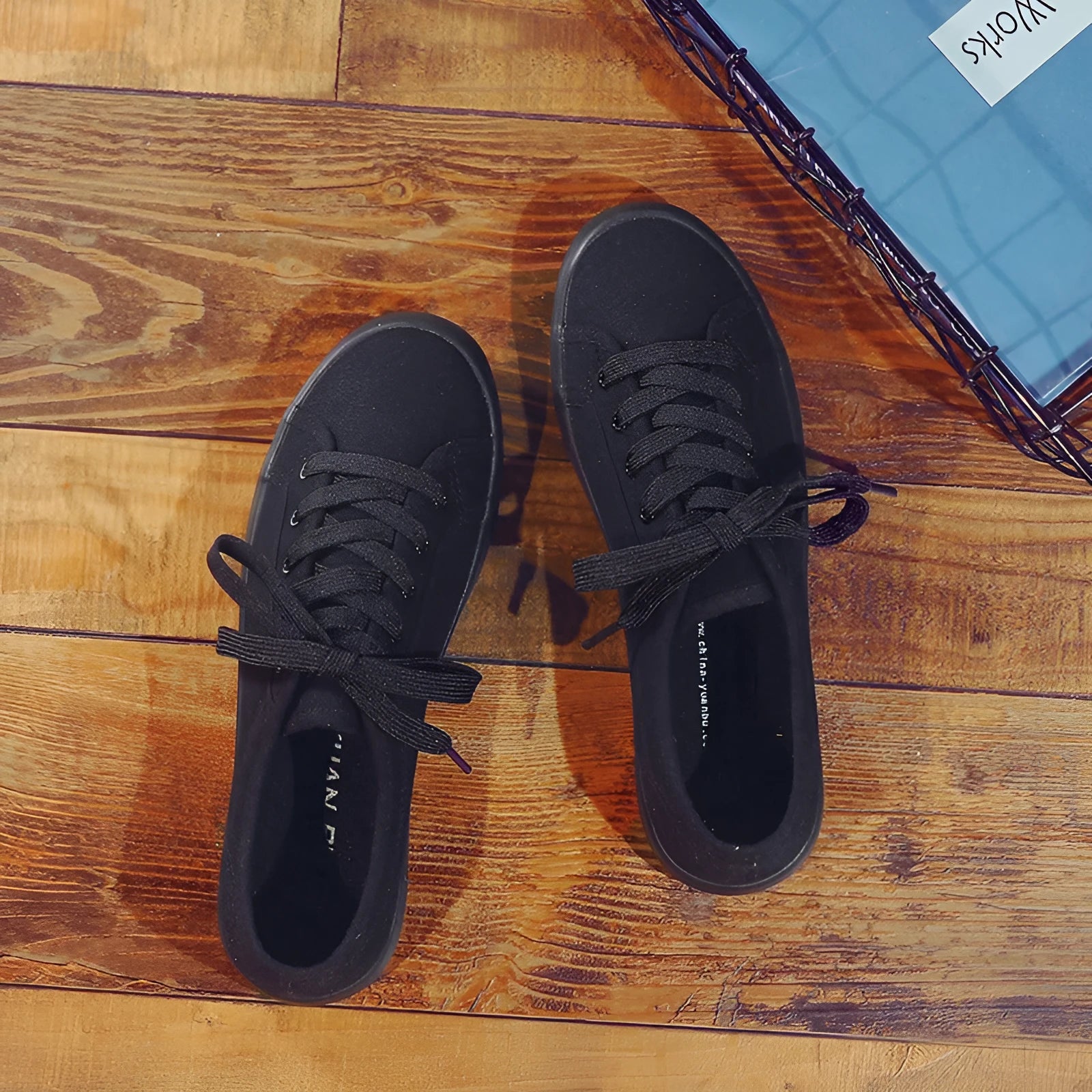 All black low-top canvas lace-up flat shoes for women with a rubber sole.