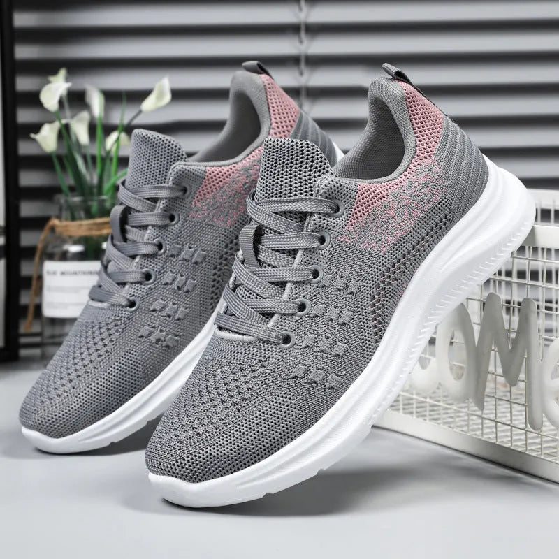 Women's black lightweight mesh sneakers with lace-up front and soft PVC sole on a white background.