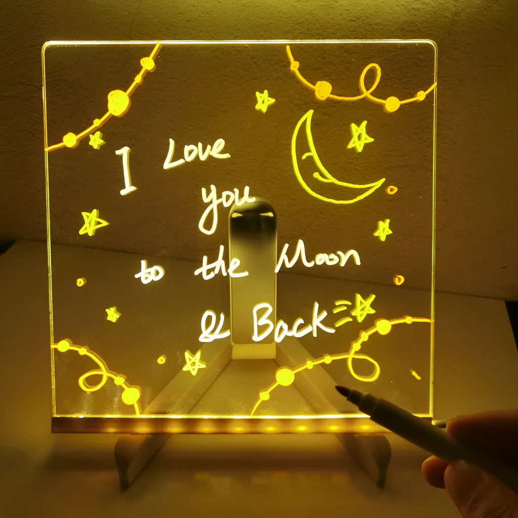 Acrylic DIY LED message board night light on a desk with handwritten drawing glowing softly.