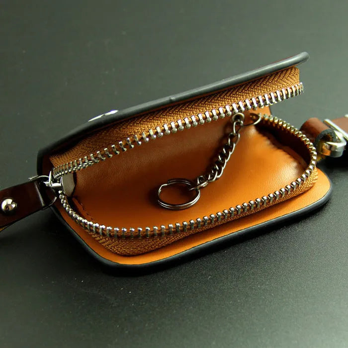 Black or brown genuine leather car key case with zipper, showing soft cowhide texture and internal size of 9.5cm by 4.5cm
