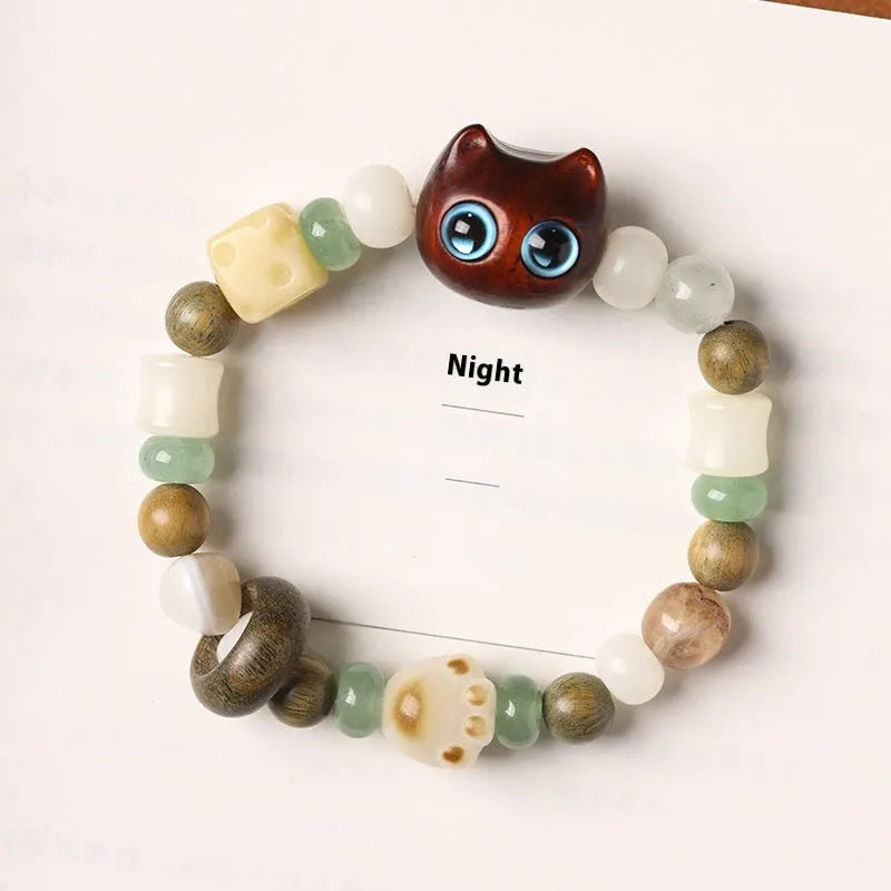 Hand-woven beaded bracelet with a cat's paw charm, multi-treasure cube, and mix of jade and wood beads.