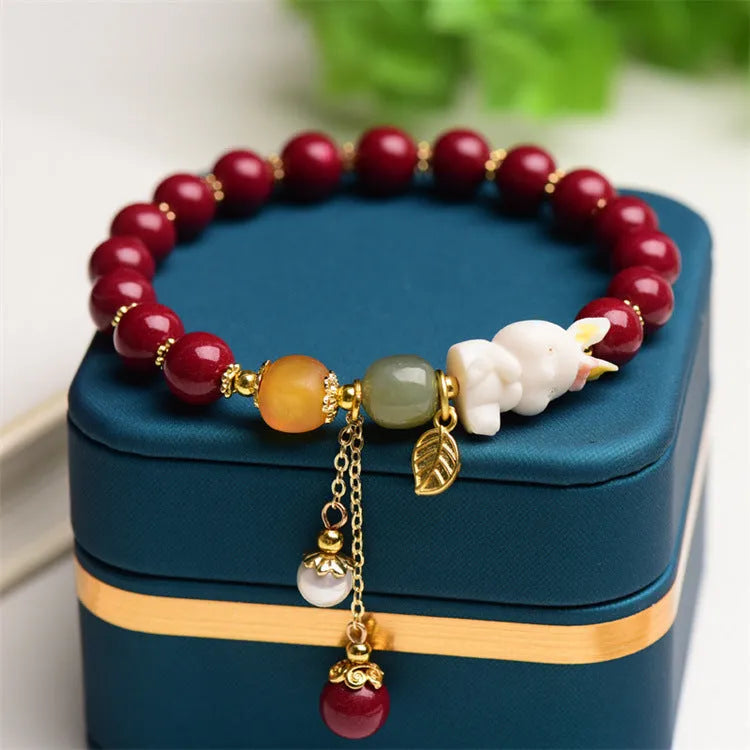 Natural Tian Yu cinnabar bracelet in purple gold sand colour with rabbit design, shown in 8mm and 10mm width options