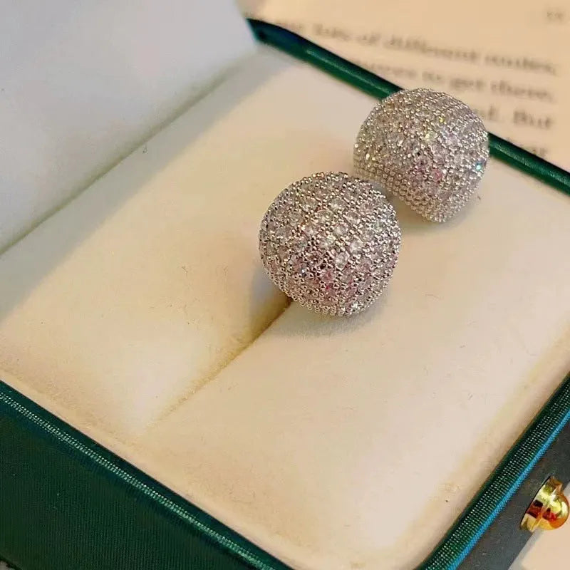 Drop-shaped geometric ear clips with full diamond setting and sphere elements in gold and white finishes