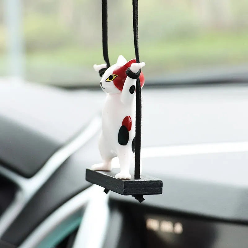 Cartoon-style resin cat pendant for car interior decoration in various colours with adjustable rope.