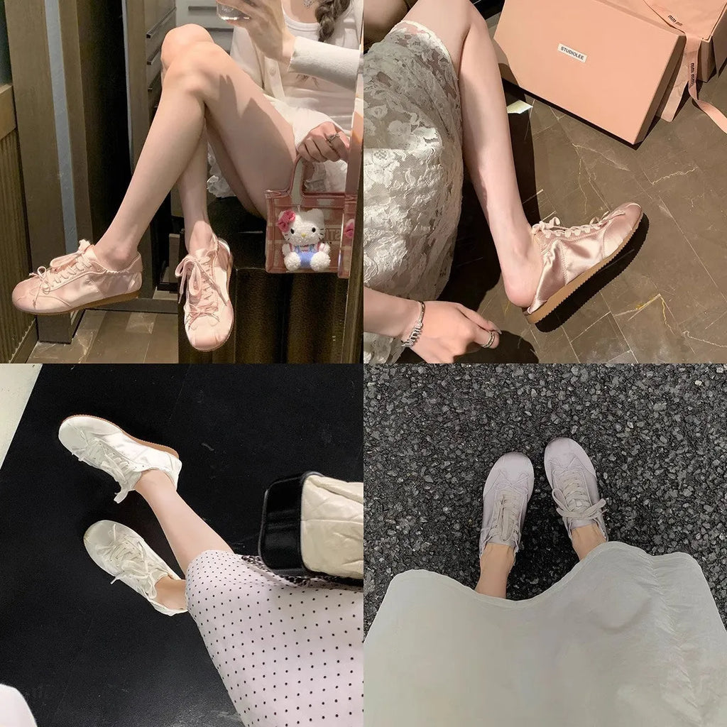 Women's silver grey satin ballet flat with front lace-up fastening and a round toe, shown on a white background.