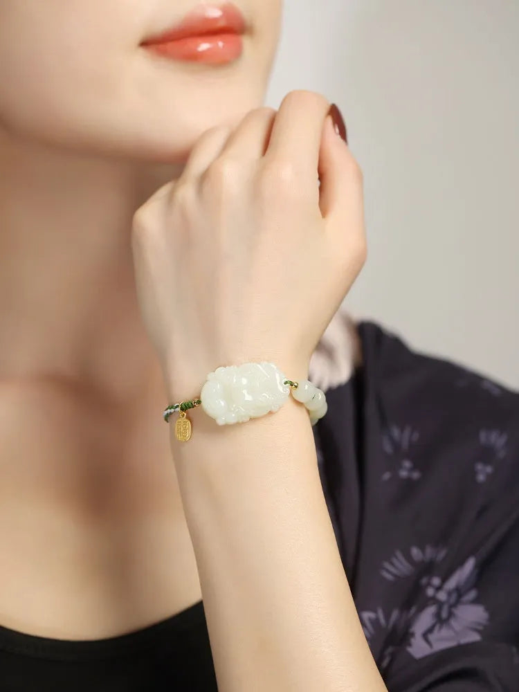 Modern red rope bracelet with a Hetian jade rabbit zodiac charm and a small silver card.
