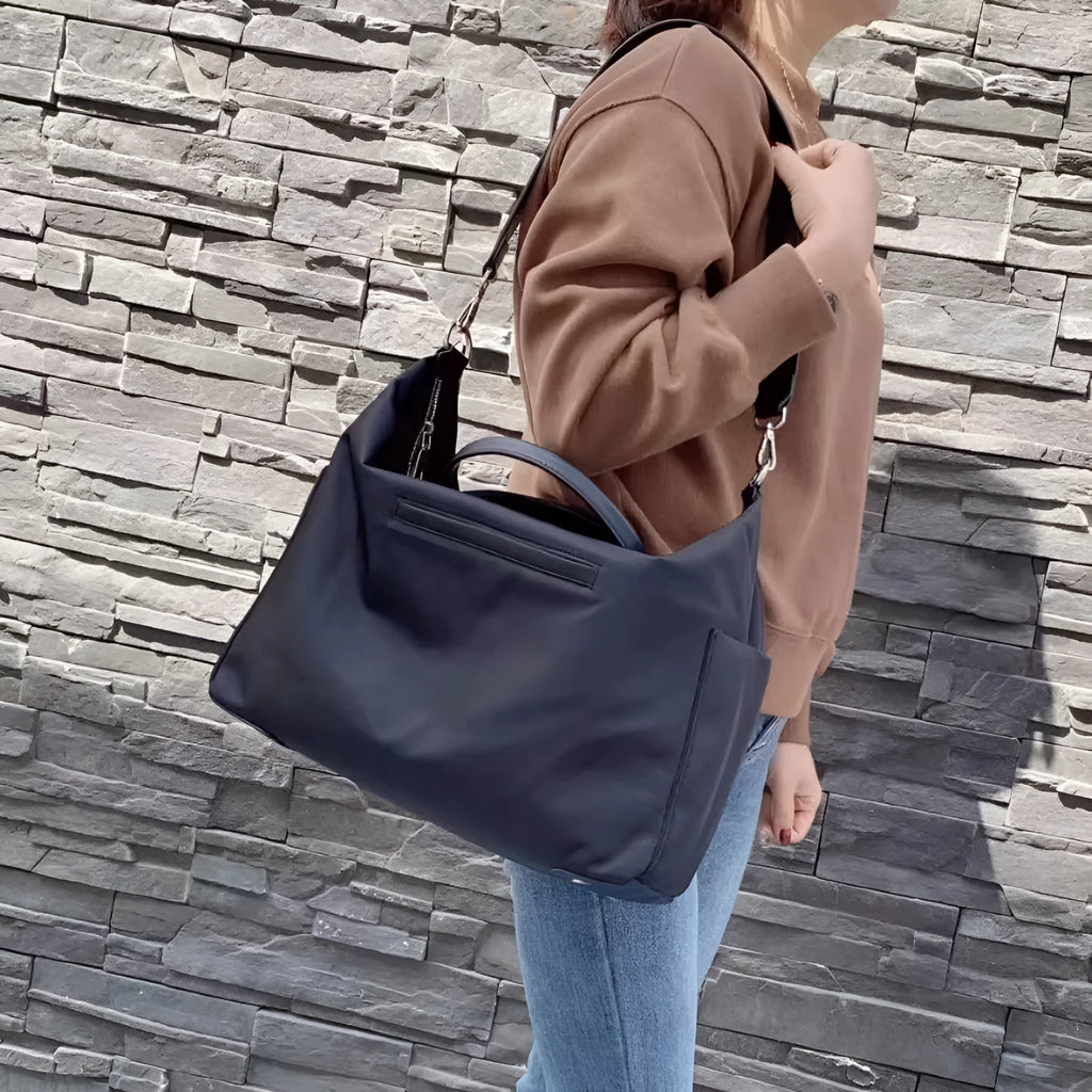 Nylon waterproof shoulder bag with leather handles in black or light khaki colour
