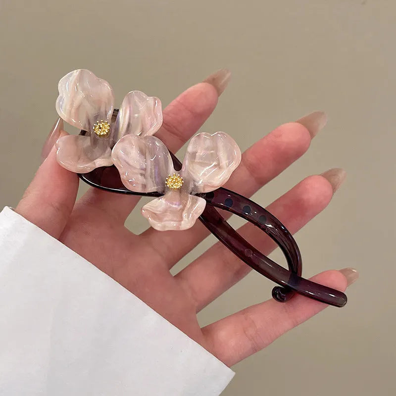 Retro flower hair bobby pin with coloured acrylic petals on a white background.