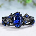Gun black and navy blue rhinestone geometric couple ring for women on a plain background.