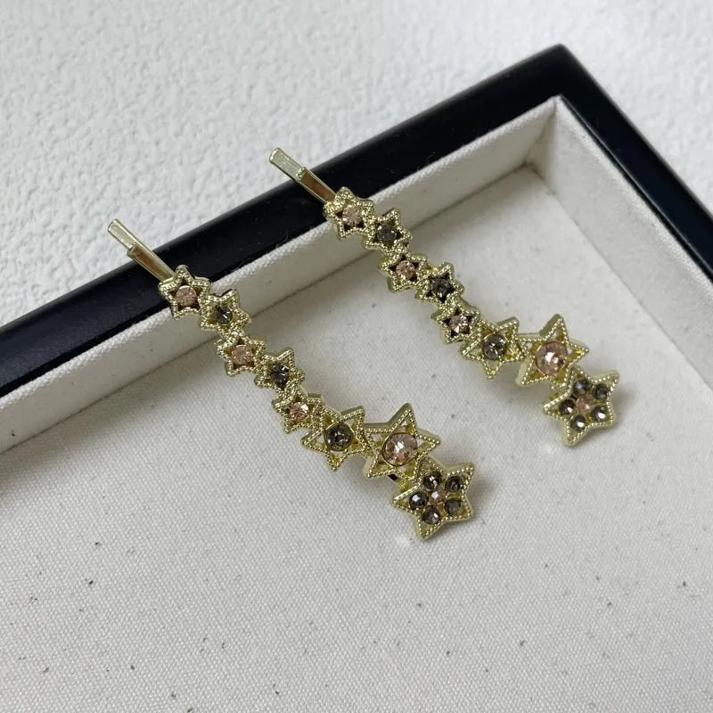 Gold metal hair barrette with a star charm and side clip for bangs.
