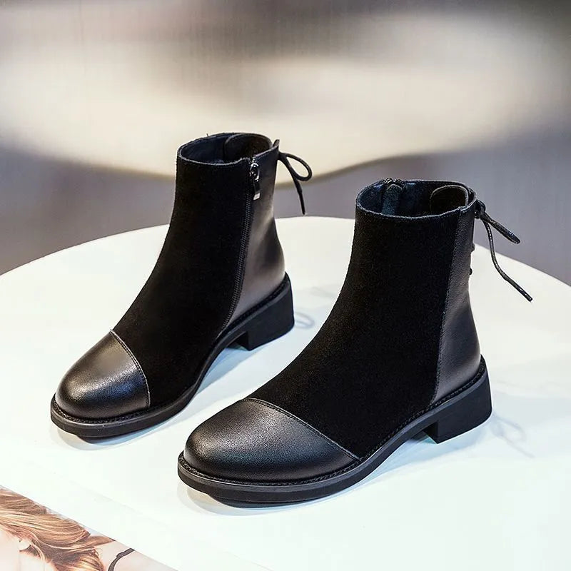 Black women's Martin boots with non-slip rubber soles and side zipper, showing round toe and short stout heel.