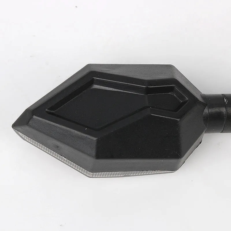 Arrow-shaped LED motorcycle turn signal lamp for 12V systems, made from black ABS plastic.