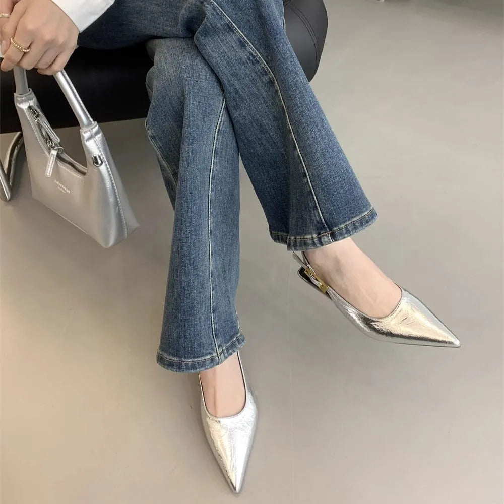Women's black leather pointed toe shoes with a thin ankle strap and a low block heel.