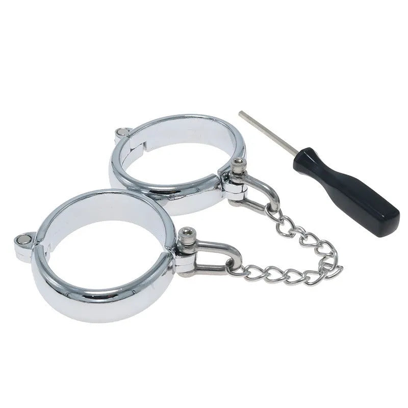 Silver zinc alloy handcuffs and footcuffs set with stainless steel chain linking on black background