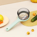 Light green kitchen peeler with attached storage bucket for catching fruit and vegetable peelings