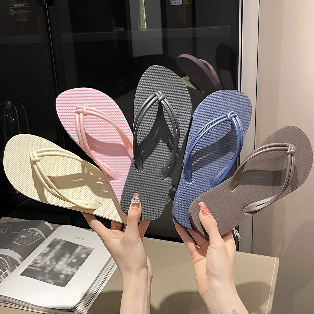 PVC women's flip flops in pink with a non-slip sole and toe-covering strap.