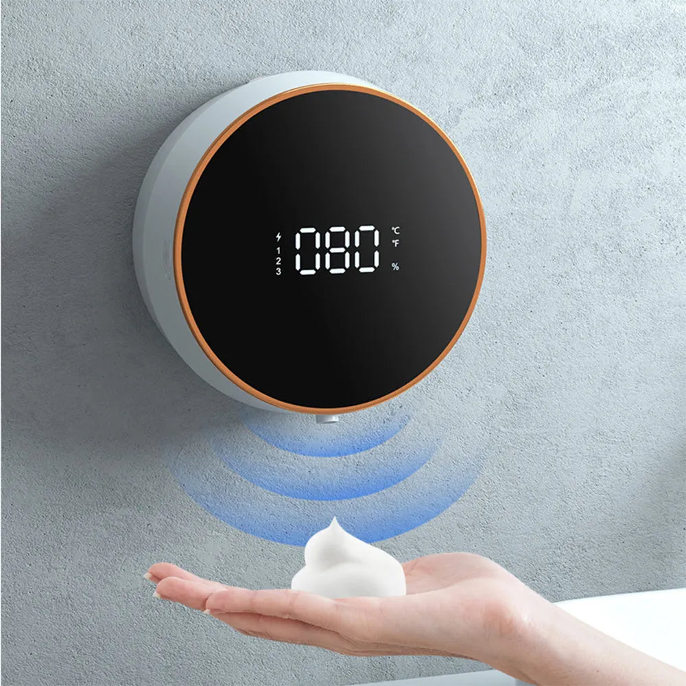 Black smart sensing foam dispenser mounted on wall with USB cable, showing sensor activation for touch-free hand cleaning