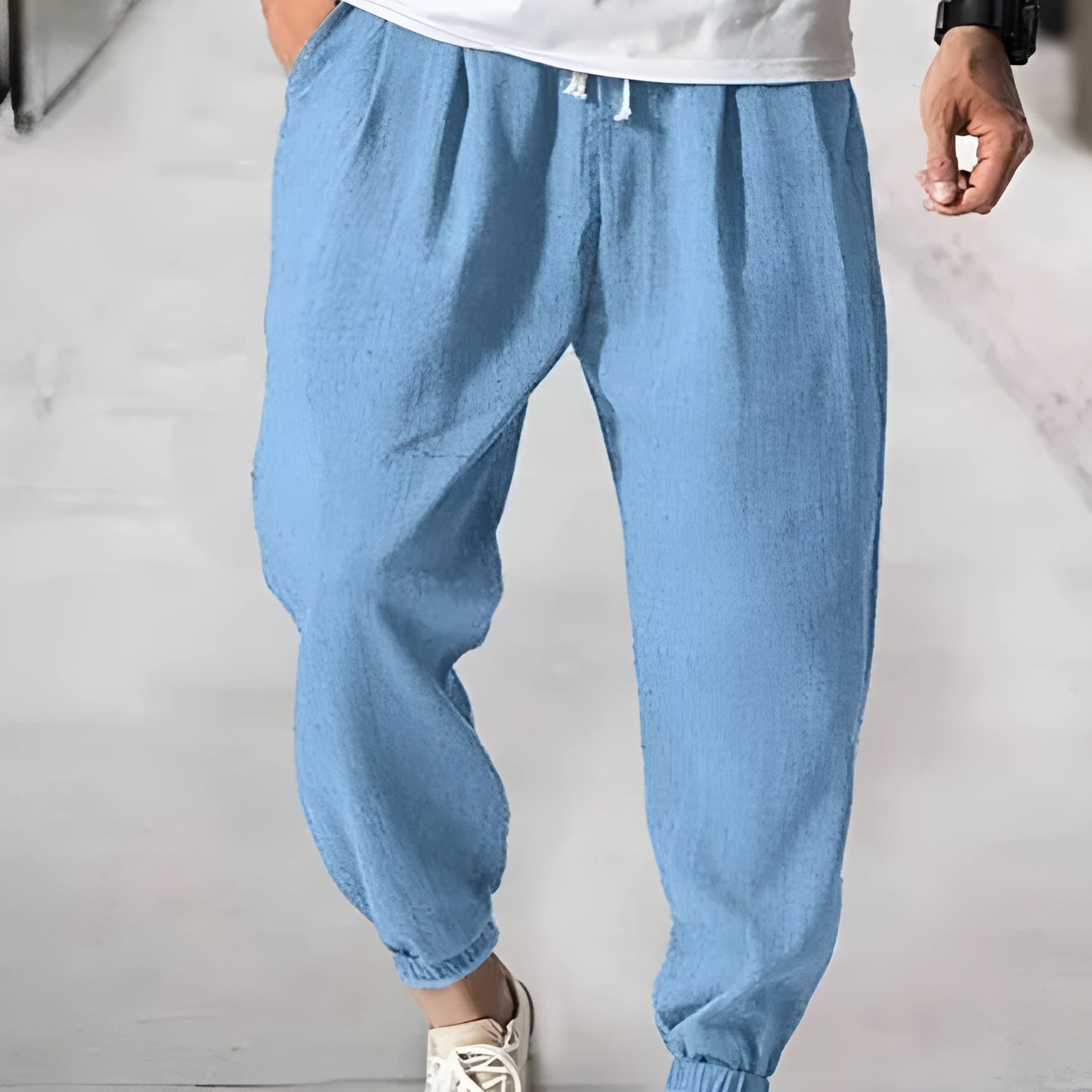 Man wearing loose light-coloured cotton trousers with a banded ankle cuff