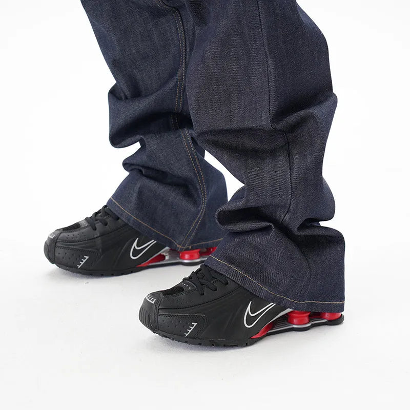 A pair of dark blue loose straight-leg men's jeans on a plain background.