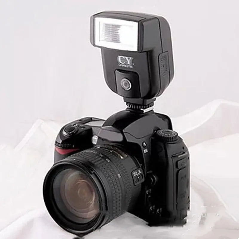Compact silver SLR camera flash with tilted head mounted on a camera hot shoe