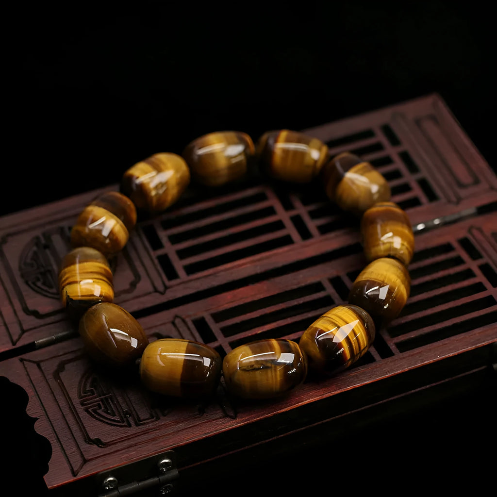 Close-up of a natural yellow Tiger Eye gemstone beaded bracelet with cat's eye effect on a wrist.