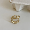 Adjustable geometric open ring with three-dimensional interlaced design and matte finish, shown in gold and silver colour options