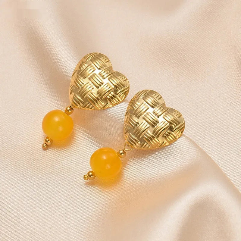 Woven big love heart ear studs with electroplated 14K gold finish, hanging beads, and titanium steel base in six colours.