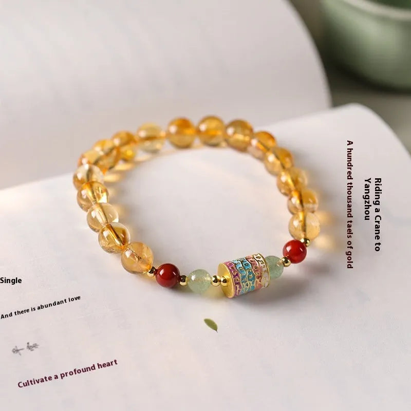Yellow citrine prayer wheel bracelet with 8mm round beads on wrist