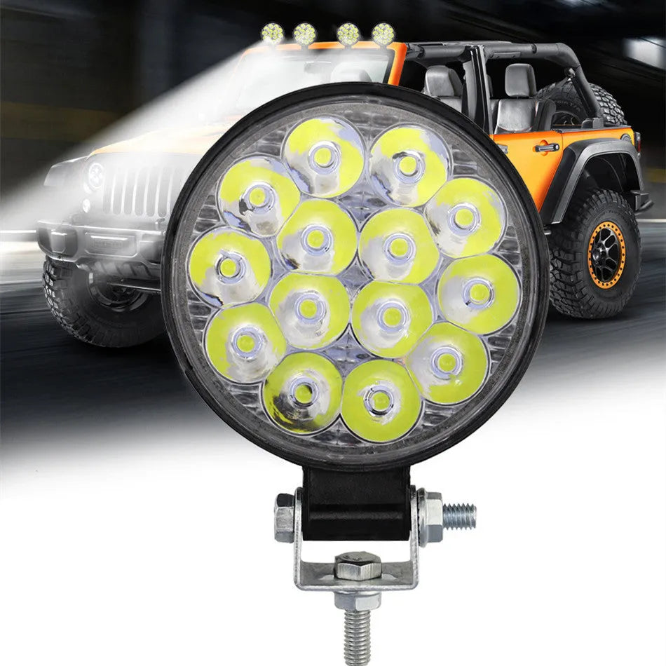 White mini round aluminium LED work light with IP67 rating for vehicle use.