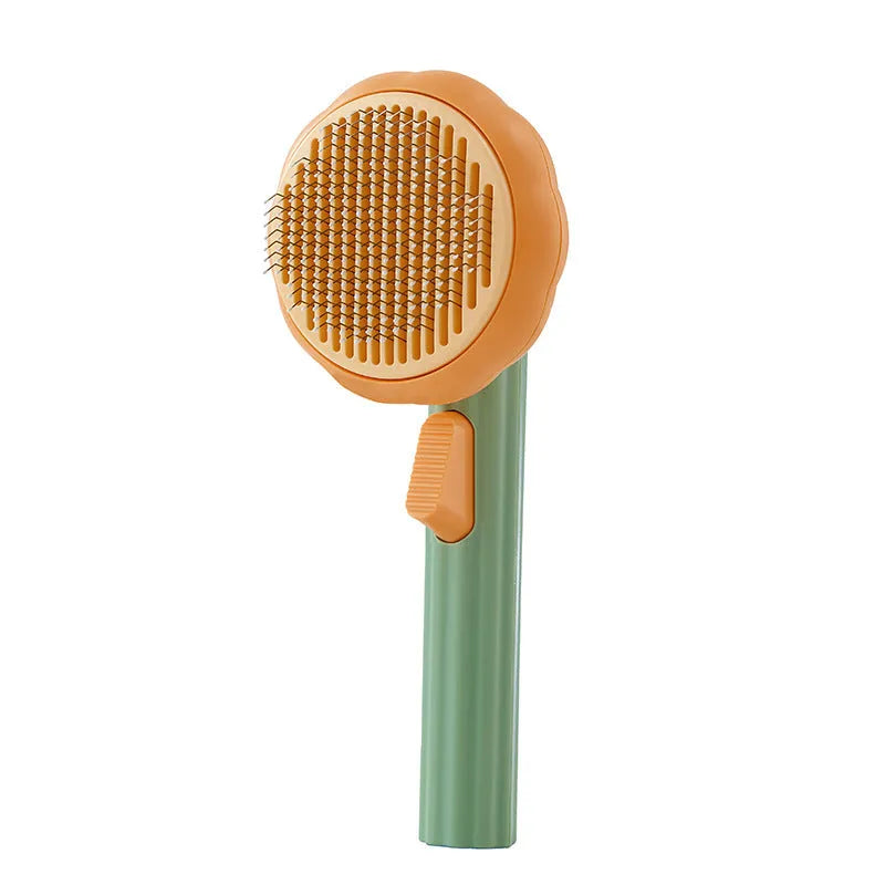 Pumpkin coloured hand-held pet grooming brush with stainless steel needles on a curved comb.
