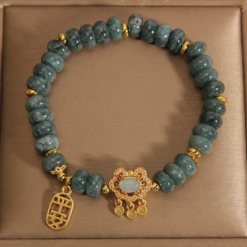 Close-up of a women's bracelet with natural emerald green jade abacus beads and a metallic alloy safety lock clasp.