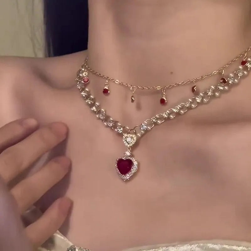 Red double layer necklace with two chains, a heart pendant, and an adjustable clasp.