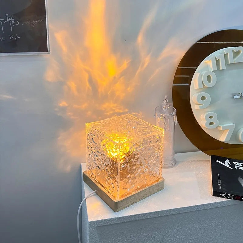 USB rechargeable LED water ripple night light with remote control on a table.