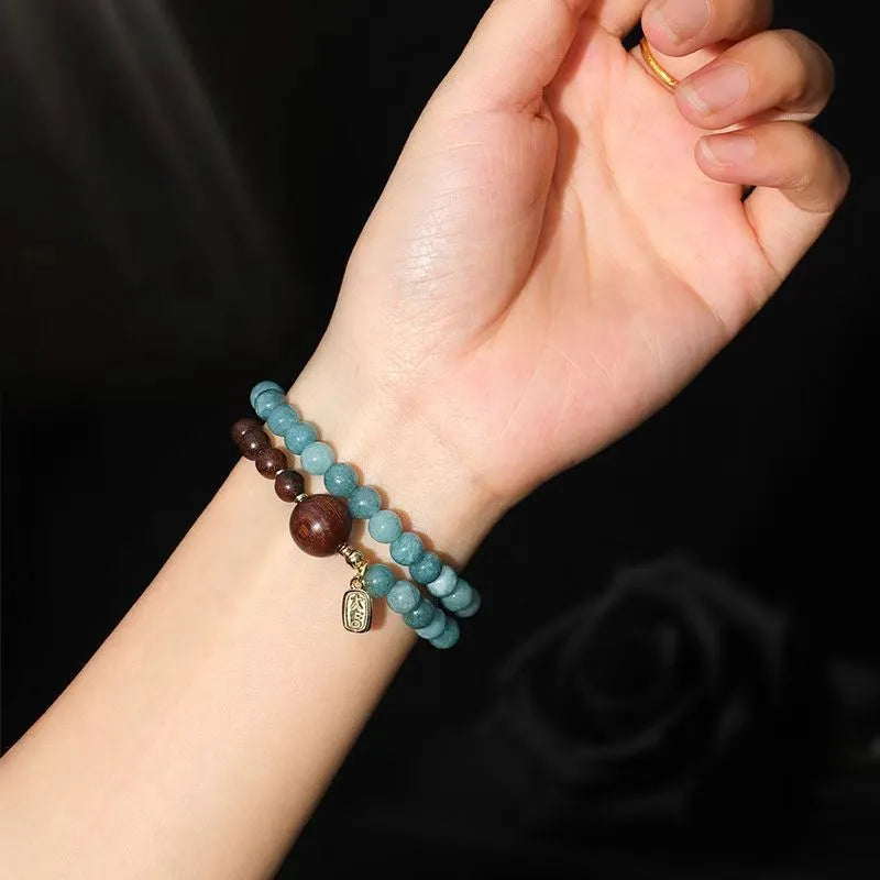 Blue natural stone beaded bracelet with golden sandalwood, guajacwood, or rosewood beads featuring fu and xi characters