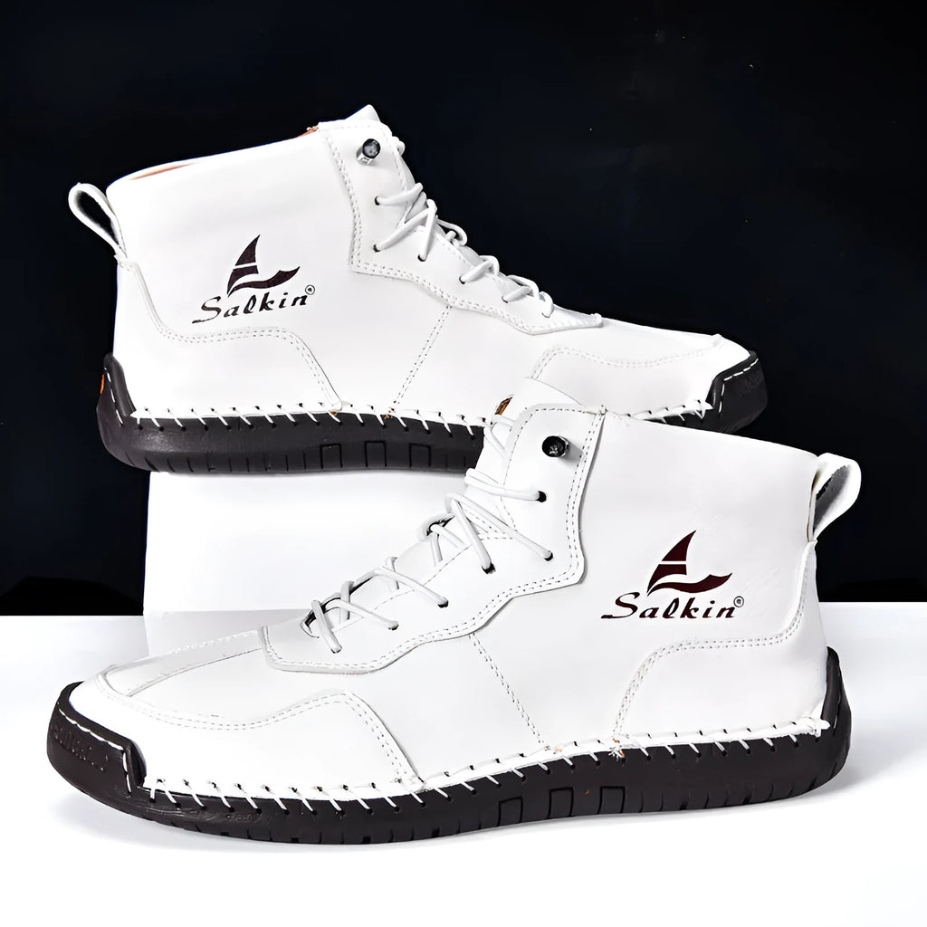 A pair of beige retro high-top casual leather boots with a round toe and elastic band fastening on a plain background.