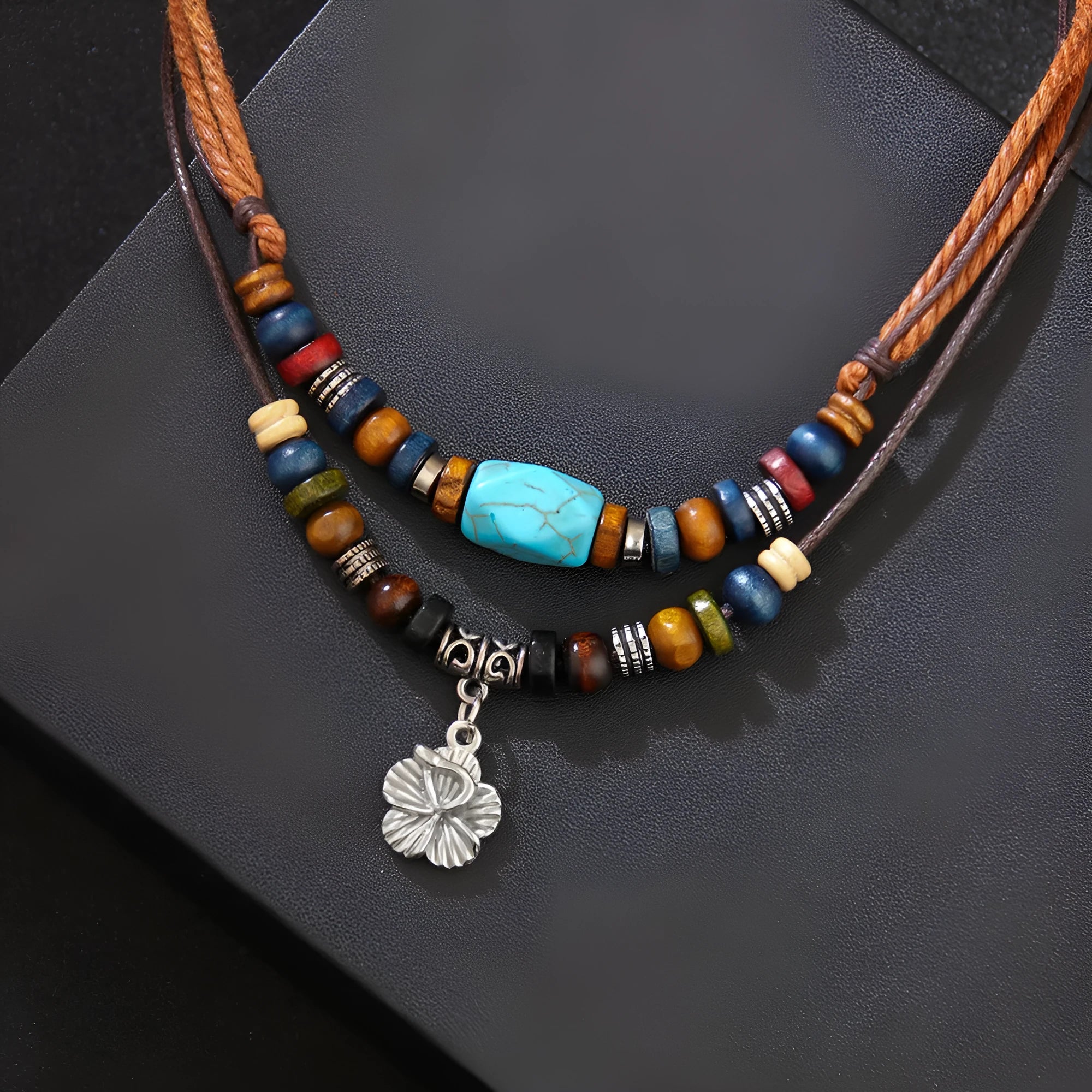 Turquoise wax rope necklace with geometric alloy pendant featuring floral engraving details