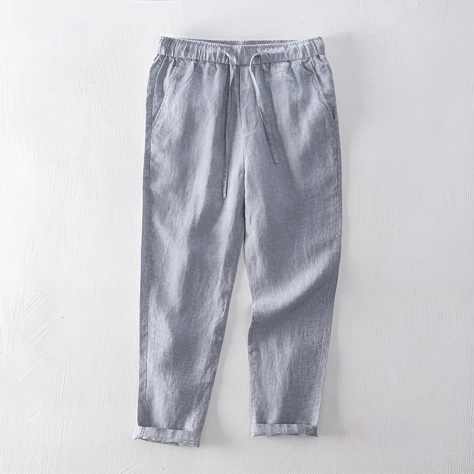 Men's straight-leg linen trousers in dark grey, showing the mid-waist and relaxed leg fit