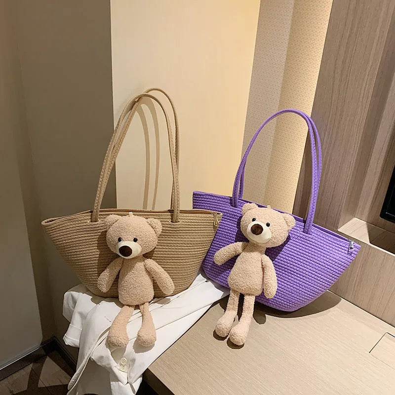 A woven dumpling-shaped shoulder bag in cotton and linen fabric with a three-dimensional front pocket.