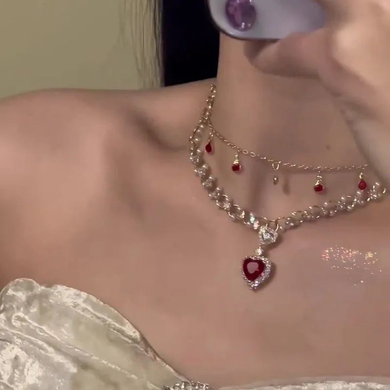 Red double layer necklace with two chains, a heart pendant, and an adjustable clasp.