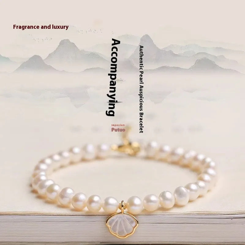 Freshwater pearl bracelet with fan-shaped shell design showing elastic and chain fastening options