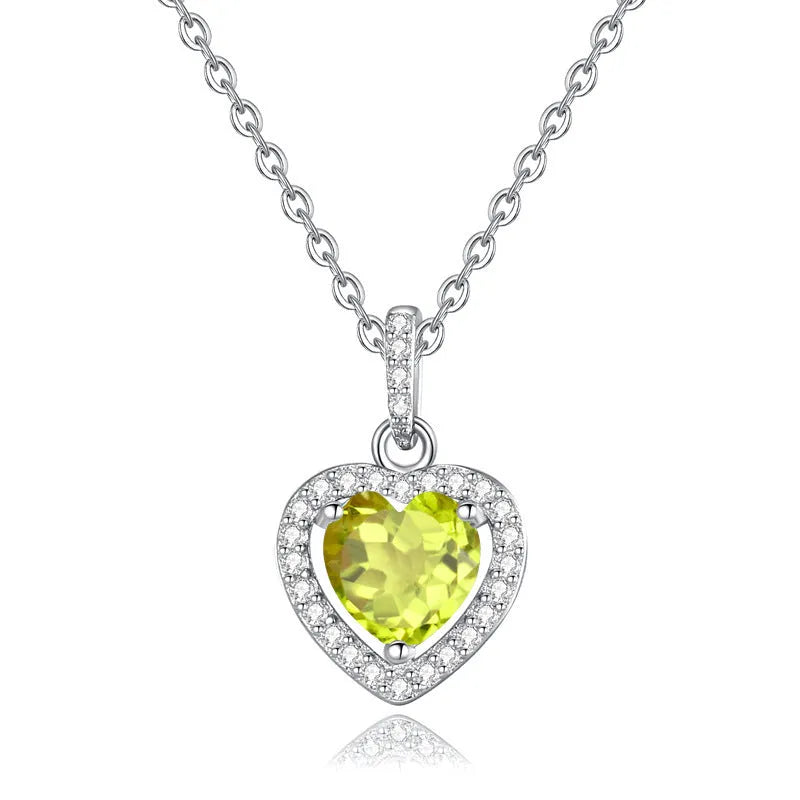 Heart-shaped sterling silver necklace with a coloured gemstone on an adjustable cross chain.