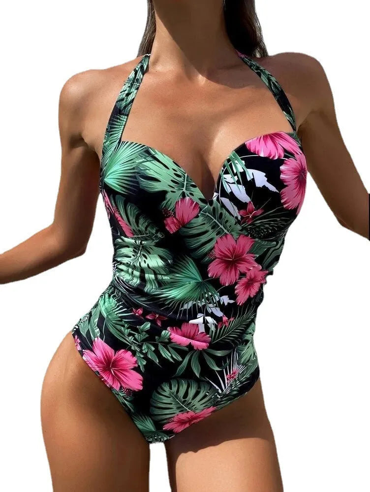 Printed halter neck one-piece swimsuit with a backless design on a mannequin.