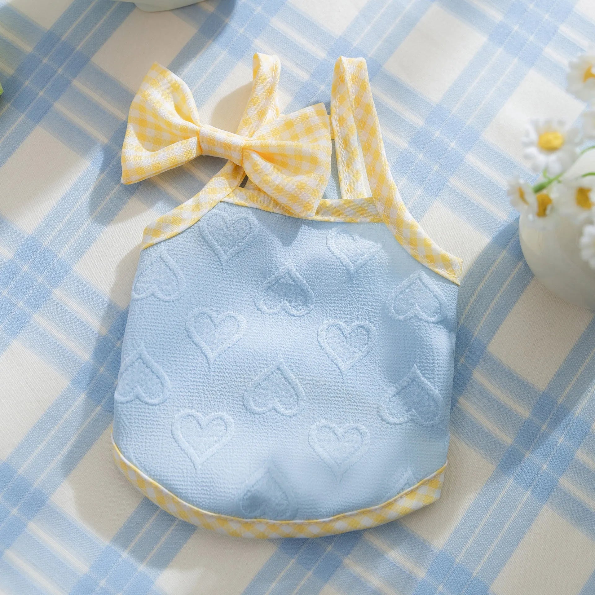 Small dog wearing blue elastic vest with bow suspenders, showing four-sided stretch design for 0.50-10.00kg pets