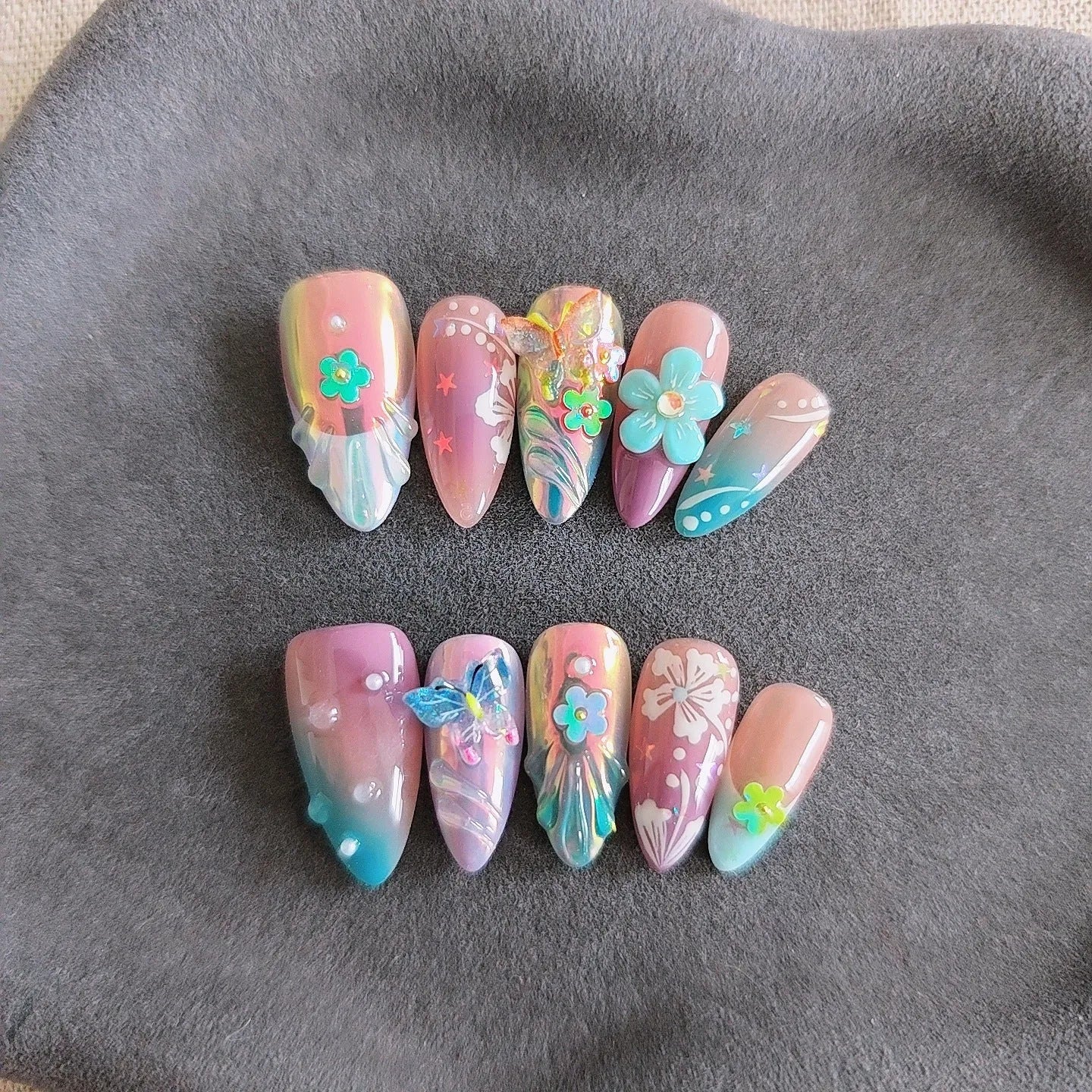 Handmade manicure sculptures showing embossed floral and butterfly patterns in four sizes (XS, S, M, L) for nail art