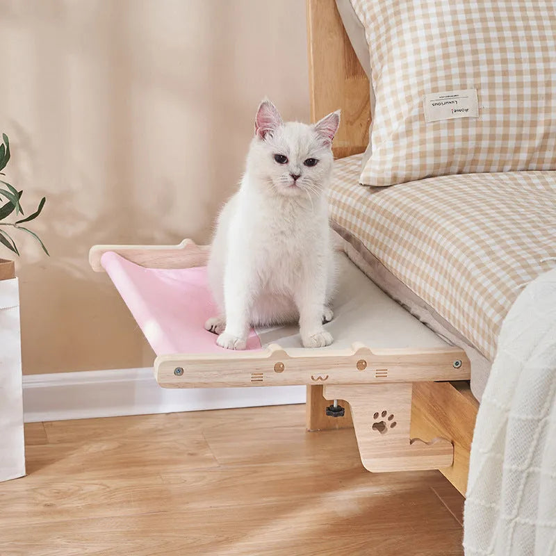 Wooden framed cat hammock bed hanging by a window, suitable for cats and small dogs.