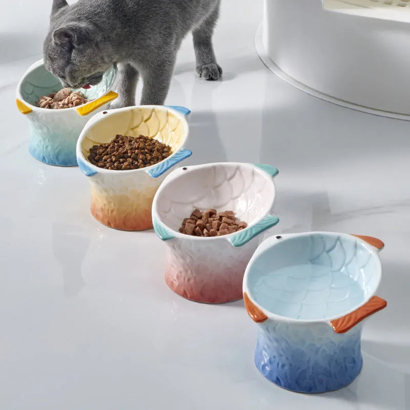 Blue fish-shaped ceramic cat bowl with 15-degree tilt angle on wooden surface